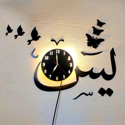 Decorative wall clock with Arabic calligraphy and butterfly designs on a light background