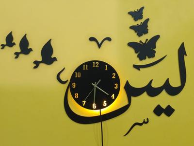 Decorative wall clock with black butterfly and bird designs on a yellow background