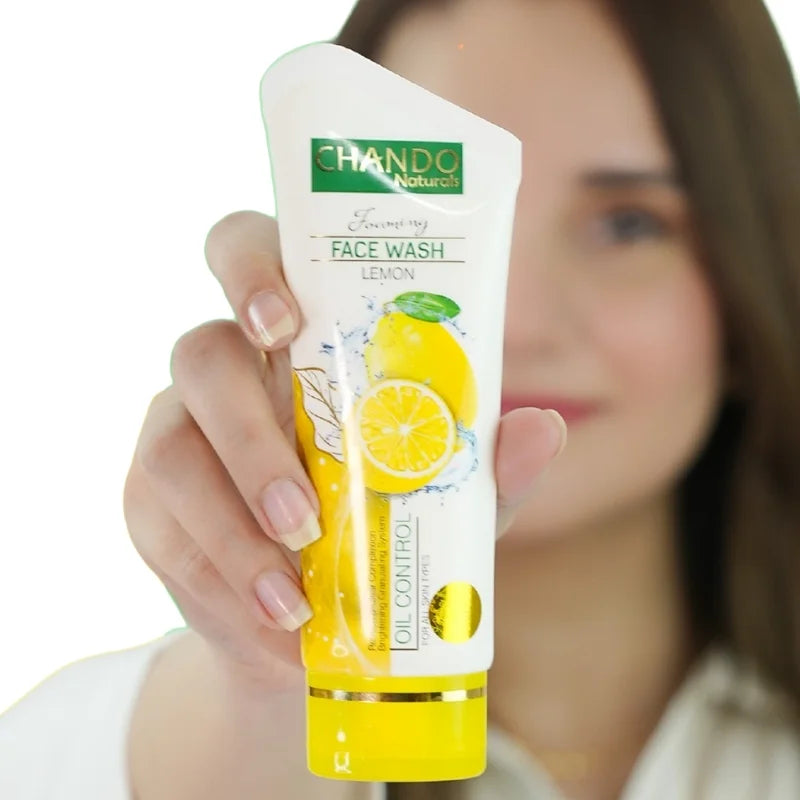Hand holding a tube of Chando Lemon Face Wash with a blurred background
