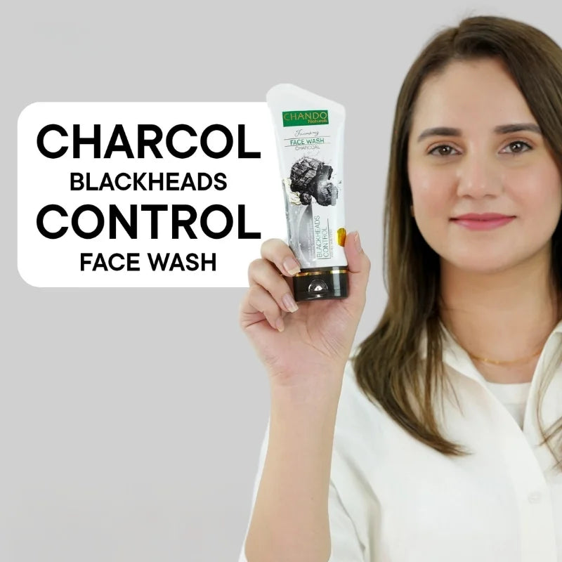 Woman holding a tube of Charcol Blackheads Control Face Wash against a gray background