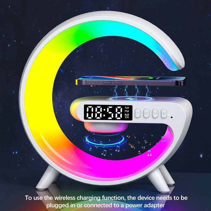 Colorful moon-shaped device with wireless charging pad and digital clock on a dark background