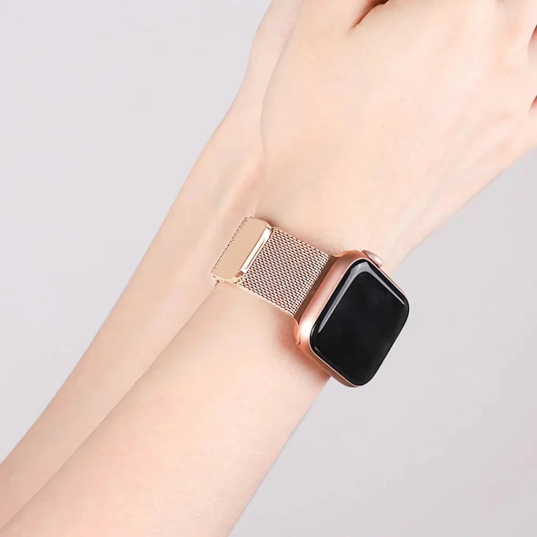 Smartwatch with a rose gold Milanese loop band on a light gray background