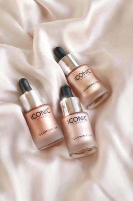 Three 'Iconic' skincare droppers on a soft fabric background