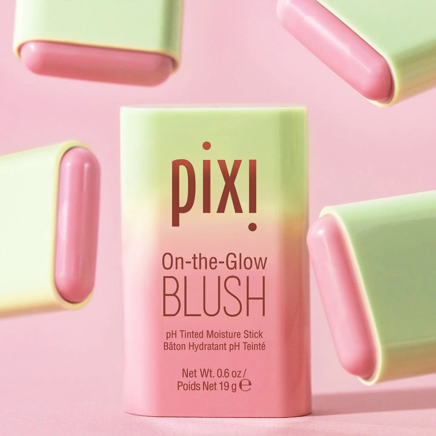  PIXI On-the-Glow Blush packaging on a pink background with pink and green blush sticks.