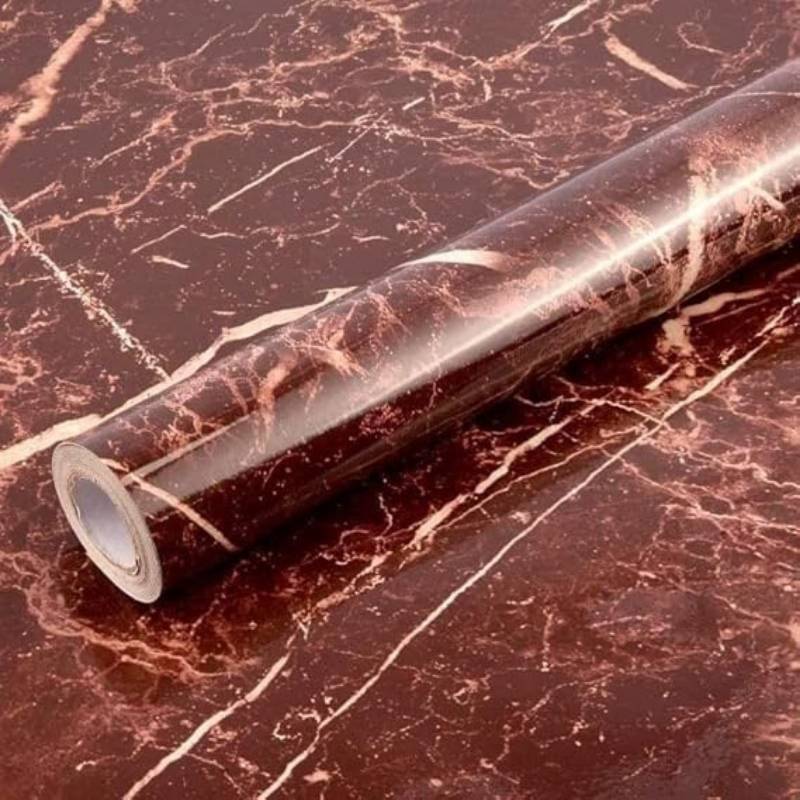 Roll of maroon marble-patterned contact paper on a matching surface
