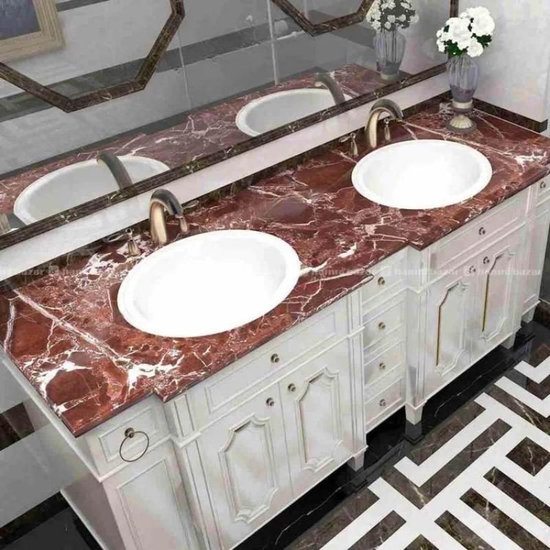 Bathroom vanity with three white sinks and a red marble countertop.
