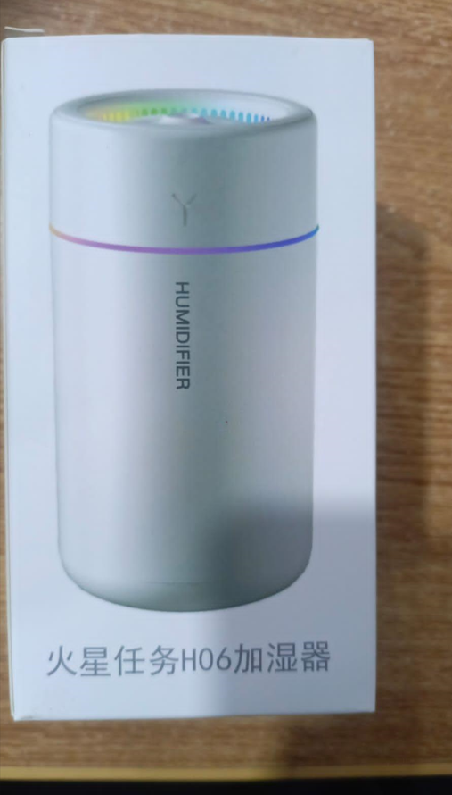 Humidifier on a wooden surface with a white box in the background