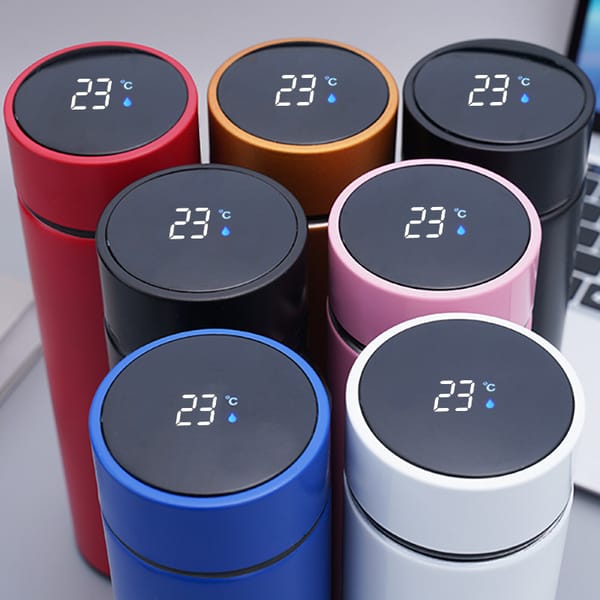 Set of colorful thermos bottles with digital temperature displays on a neutral background.