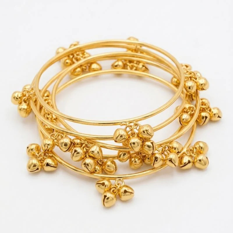 Set of gold bangles with decorative elements on a white background