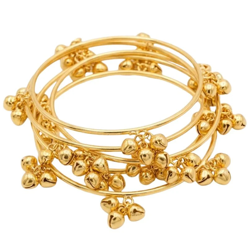 Stack of gold bangles with decorative elements on a white background