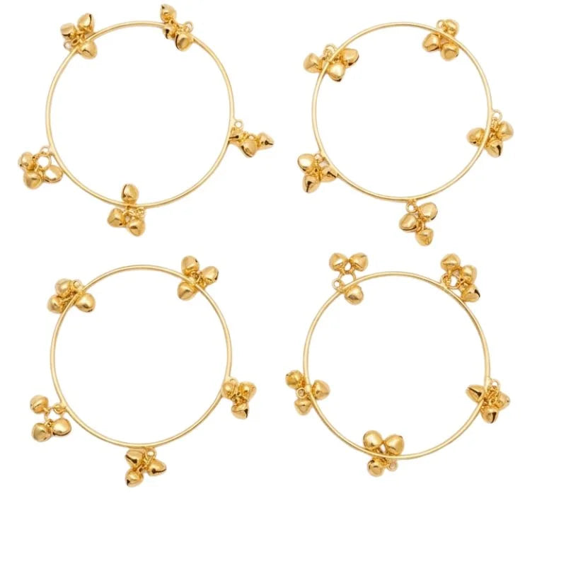 Set of four gold hoop earrings with floral designs on a white background
